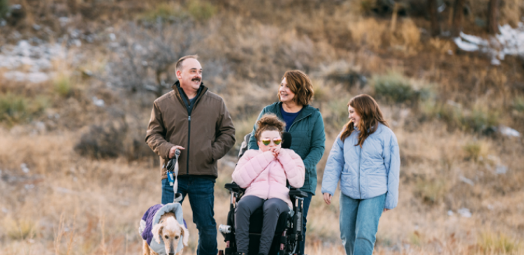 Maddy, age 20, living with Rett syndrome, with her family mobile
